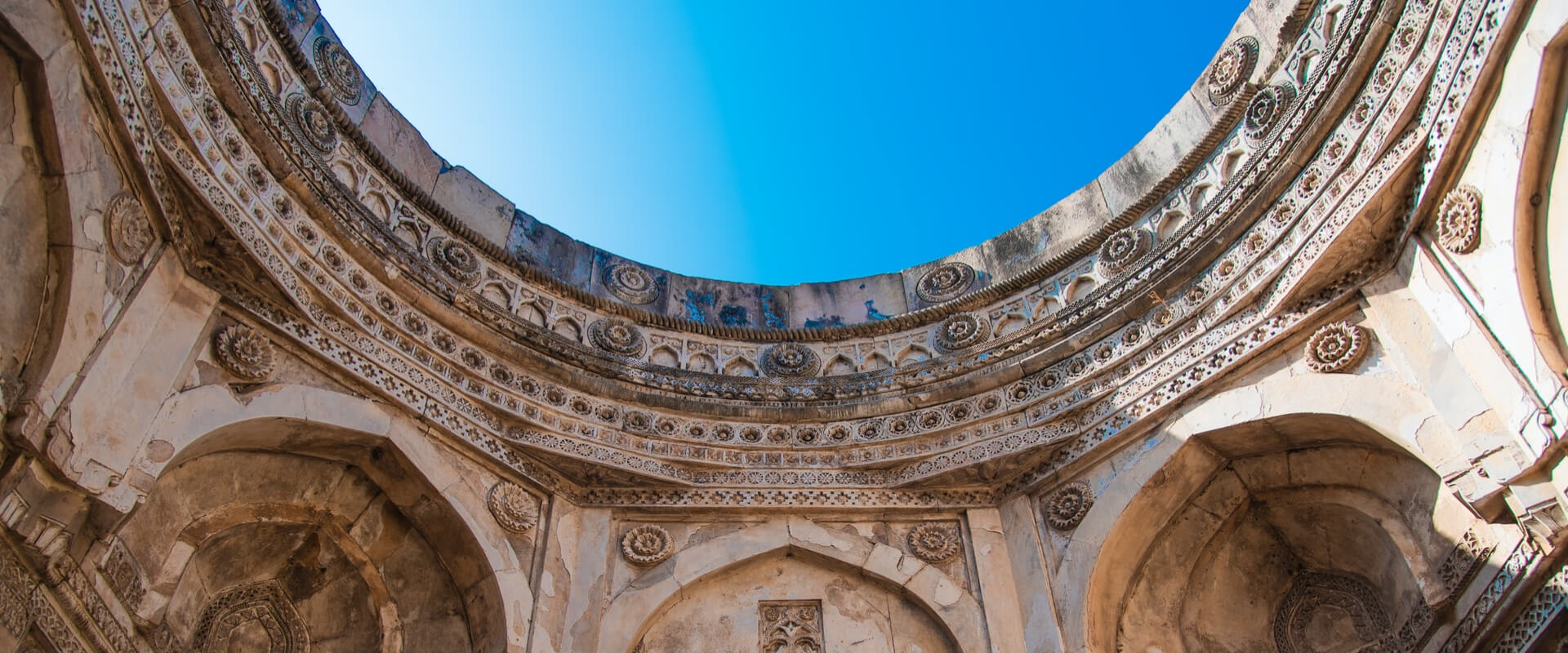 Ornate carved stone dome open to blue sky — Jaipur heritage architecture