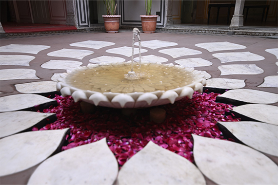 Padmaa courtyard — lotus fountain with rose petals on intricate stone flooring